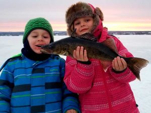 peche-blanche-lacsaintjean-enfants-vacance idée activité a faire au lac saint jean entre famille ou amis en hiver, la pêche blanche sur glace en formule tout inclus avec transport en motoneige et cabane à pêche