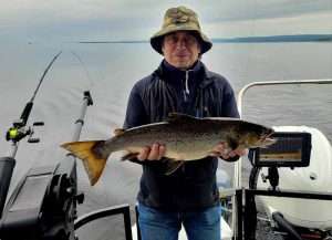 grosse-ouananiche-record-lacstjean-peche-bateau-été-aventure-lac-st-jean belle grosse ouananiche landlocked salmon record trophé capturé au québec canada saguenay lac st jean accompagné du guide de pêche charles dufour et du bateau de pêche ponton de aventure lac saint jean en 2023 ouananiche capturé avec downrigger et cuillère spoon canne okuma white diamond et moulinet convector